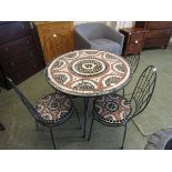 A specimen mosaic tiled top circular metal supported table with a set of four matching chairs