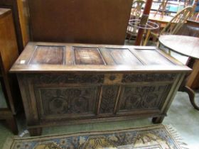 A late 19th century/early 20th century oak coffer with carved panel front