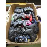 A tray containing a large selection of gaming controllers for various platforms to include Xbox, PC,