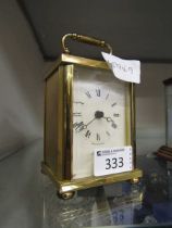 A mid-20th century style brass cased carriage clock by Rapport on brass bun feet