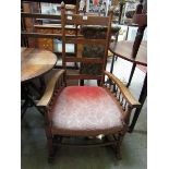 An early 20th century spindle armed rail back rocking chair
