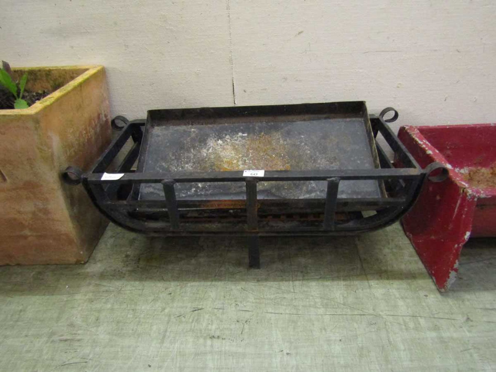 A black metal fire grate with ash tray