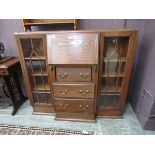 An early 20th century oak bureau bookcase, having a fall with three drawers being flanked by