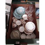 A tray containing decorative cups, saucers, and cut glassware