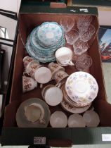 A tray containing decorative cups, saucers, and cut glassware