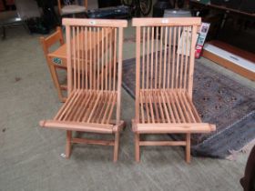 A pair of teak folding garden chairs