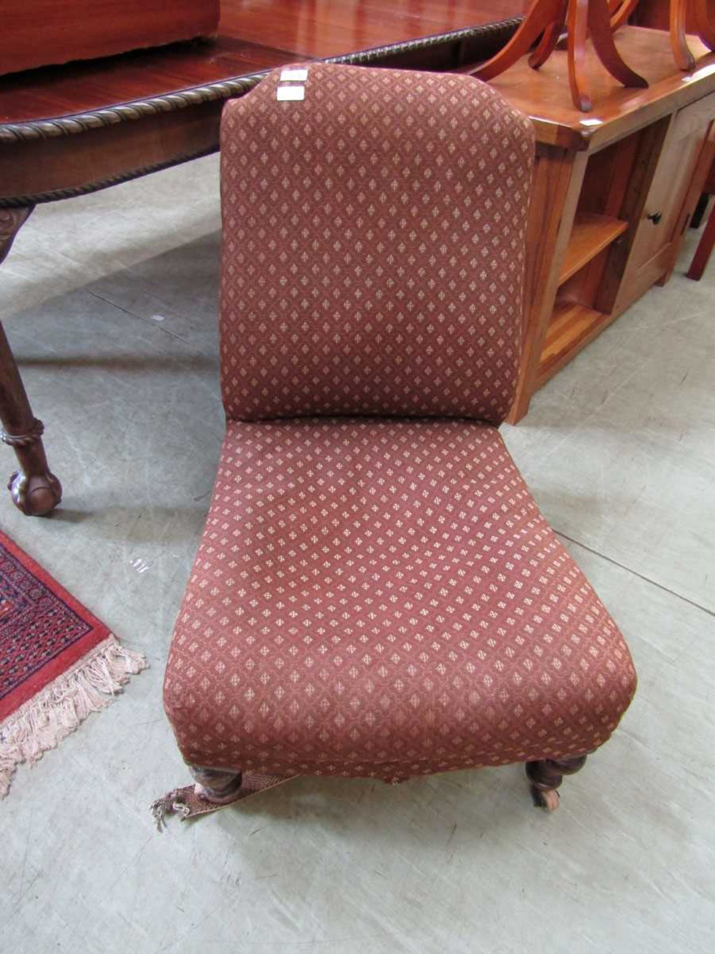 A Victorian nursing chair upholstered in a brown diamond design fabric