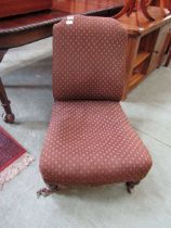 A Victorian nursing chair upholstered in a brown diamond design fabric