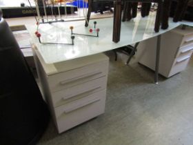 A modern white pedestal computer desk with smoked glass top