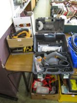 A cased angle grinder along with a cased sander, a boxed electric saw, and a belt sander