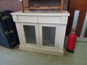 An upcycled pine cabinet having meshwork doors