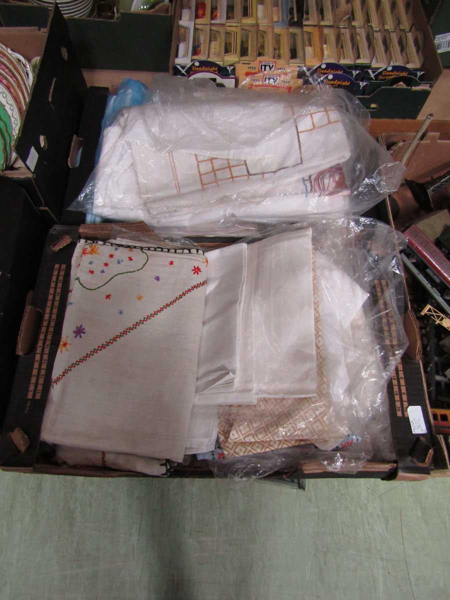 Two trays of lace, linen and embroidered fabrics, mainly from Harrods