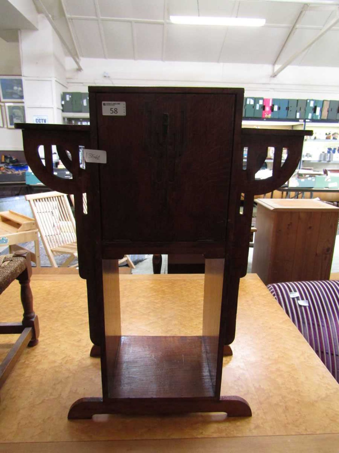 An early 20th century oak cabinet having pull down flap