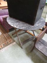 A weathered wooden folding circular garden table