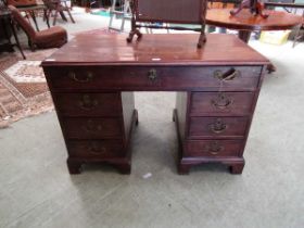 A George III mahogany desk, the top with applied moulded edge, above a long drawer fitted with a