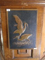 A mid-20th century embossed copper plaque of storks