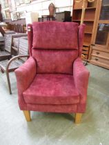 A salmon pink upholstered wing armchair