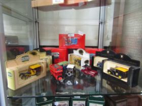 A collection of boxed and unboxed die cast buses, horse and carriages, and vans