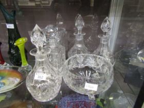 An assortment of six pieces of crystal glassware consisting of four decanters, a bowl, and a vase