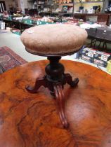 A Victorian mahogany piano stool with circular seat