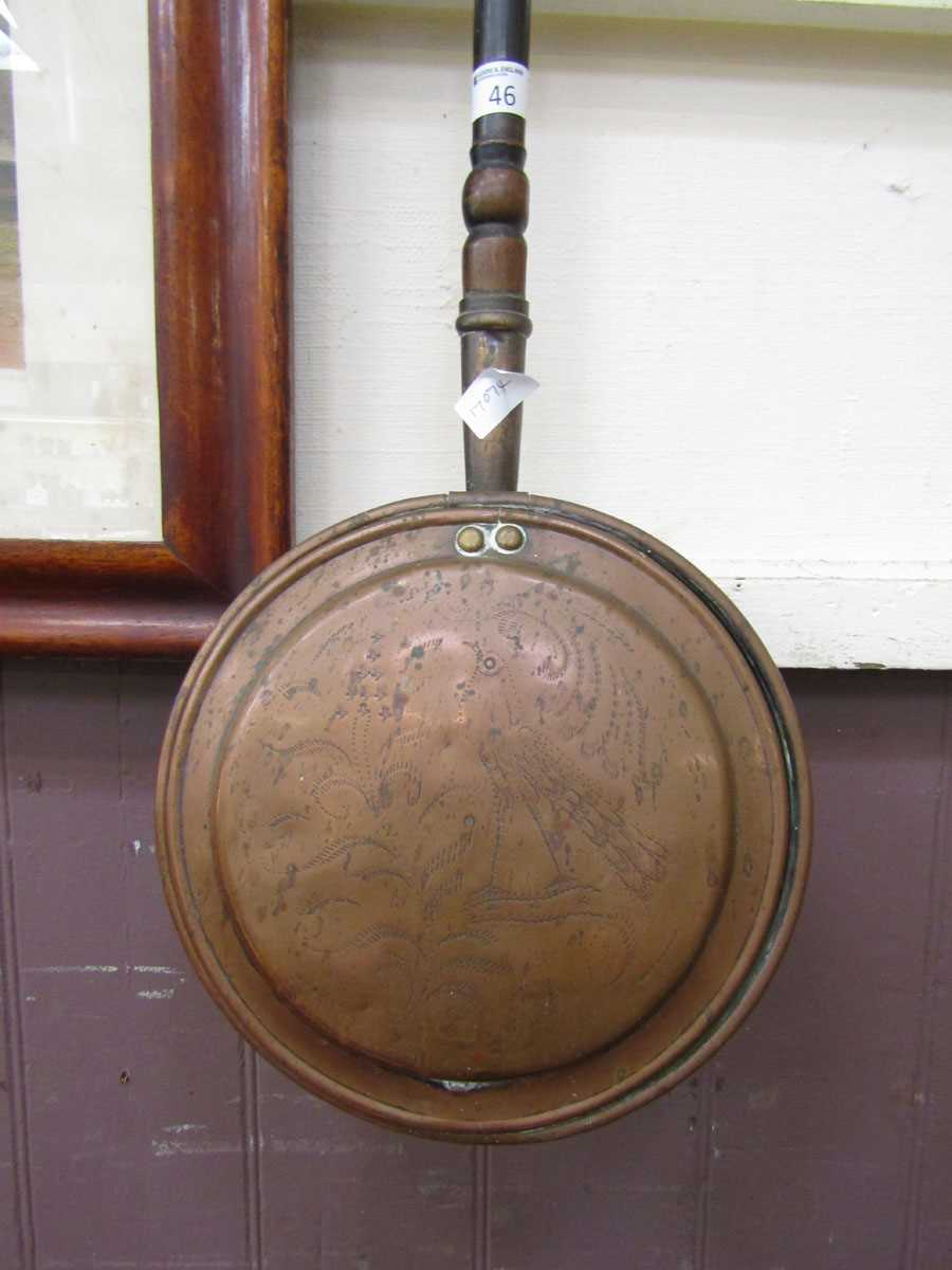 A brass and copper bed warming pan