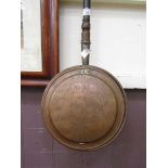 A brass and copper bed warming pan