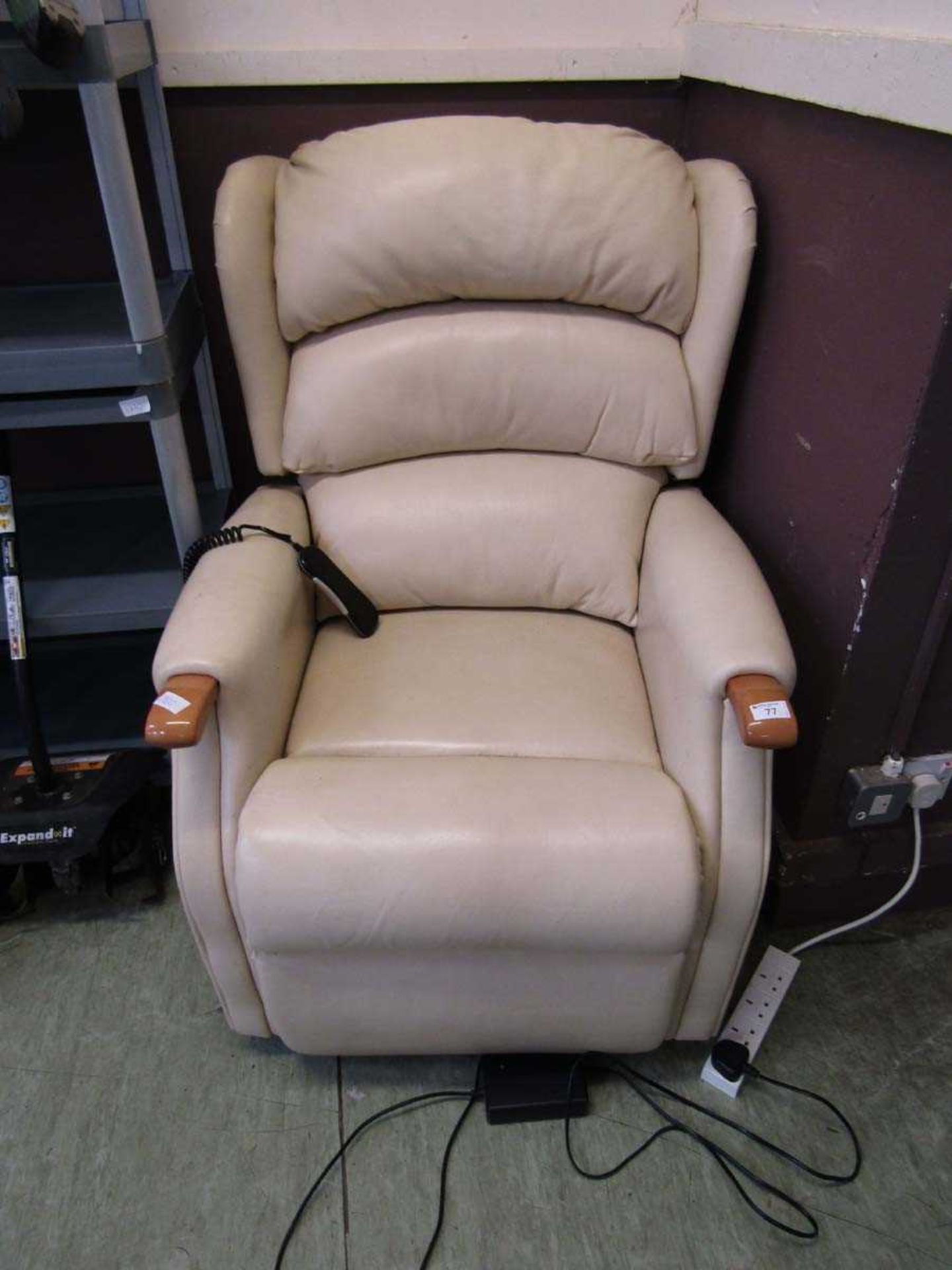 A cream leather upholstered electric rise and recline chair