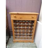 A waxed pine cabinet having single drawer above metalwork wine rack