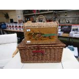 A Spanish shopping basket with hand painted design together with a wicker picnic basket