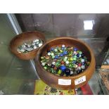 Two turned wooden bowls containing marbles and pebbles