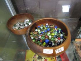 Two turned wooden bowls containing marbles and pebbles