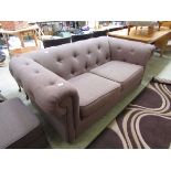 A modern brown upholstered Chesterfield style sofa