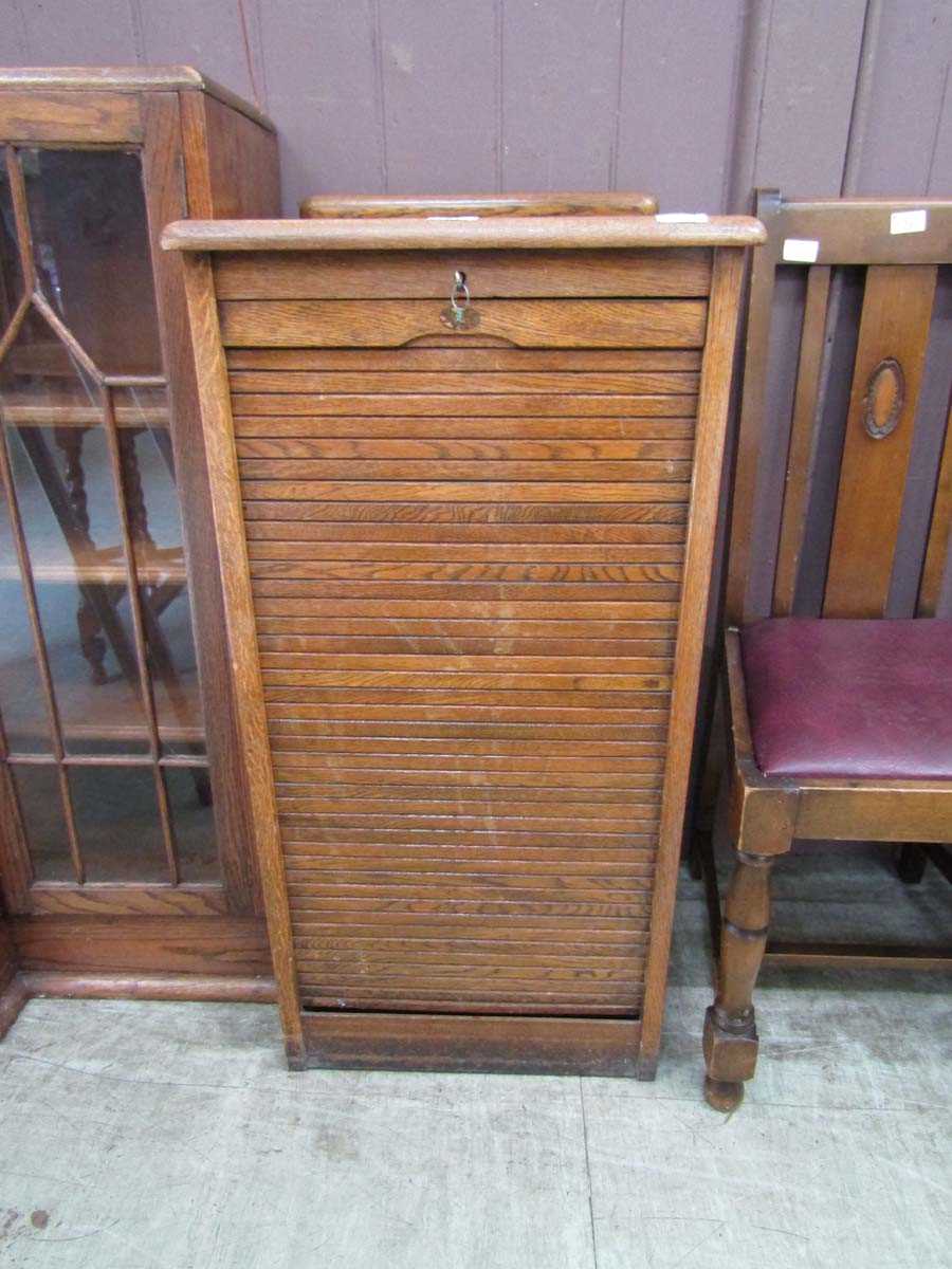 An early 20th century oak tambour fronted stationery cabinet having nine drawers