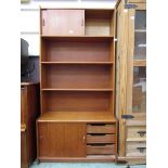 A mid-20th century teak cabinet having a pair of sliding doors to top above open storage, the base
