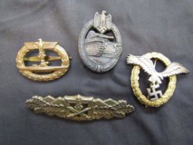 A bag containing one cased and three uncased reproduction German military badges/medals