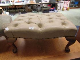 A cream leather upholstered footstool on cabriole supports