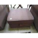 A brown upholstered modern pouffe with lift up lid concealing storage space