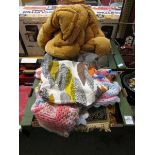 Two trays containing a large assortment of textiles to include quilted duvets, crochet blankets,