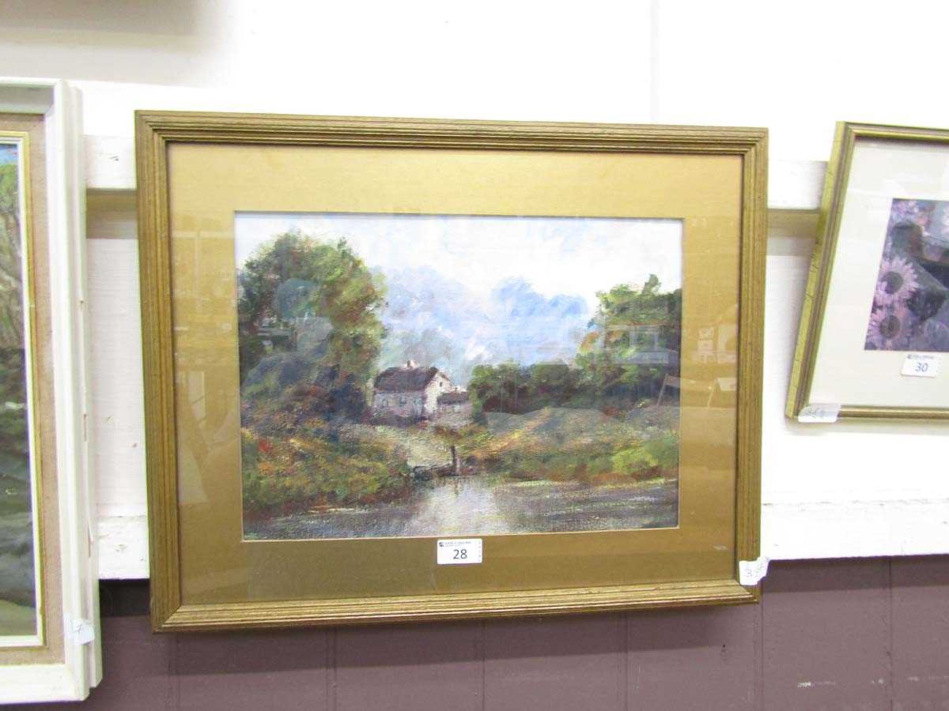 A framed and glazed oil of cottage by lake scene