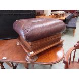 A reproduction oak foot stool having a brown leather upholstered cushion to top