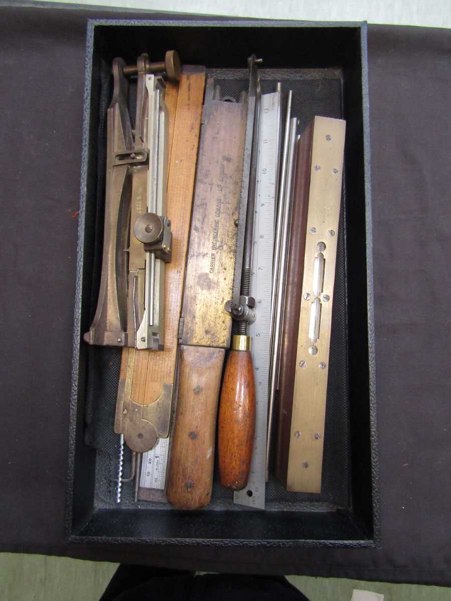 A box containing early 20th century carpentry tools to include measures, saws, etc