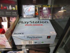 A boxed Sony Playstation along with four games