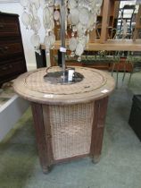 An early 20th century circular topped wooden cabinet with woven top and sides