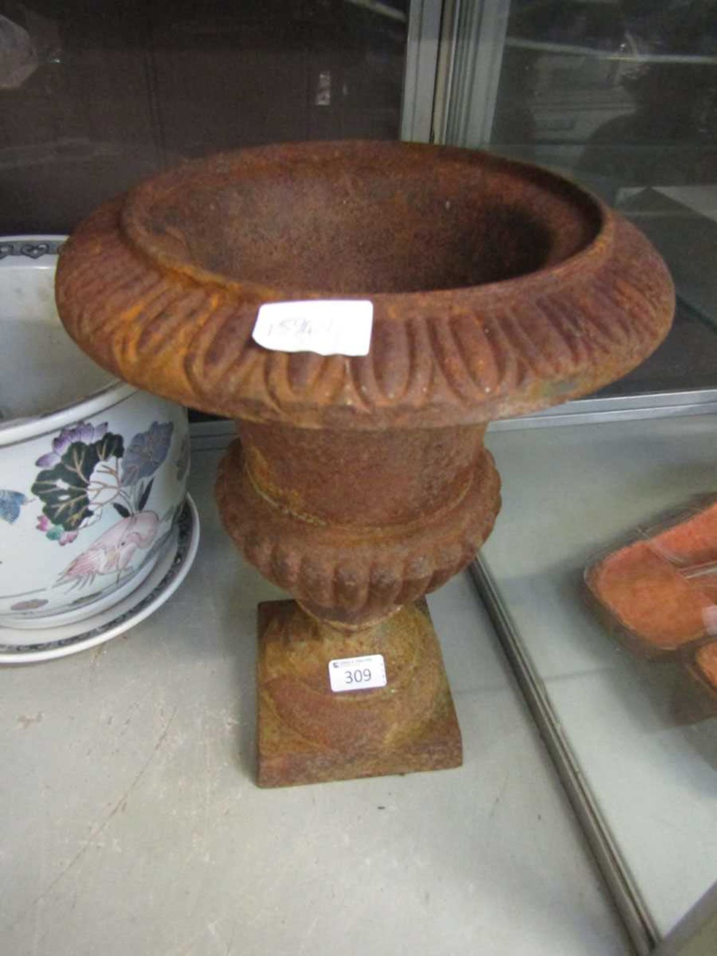 An early 20th century rusted cast metal urn