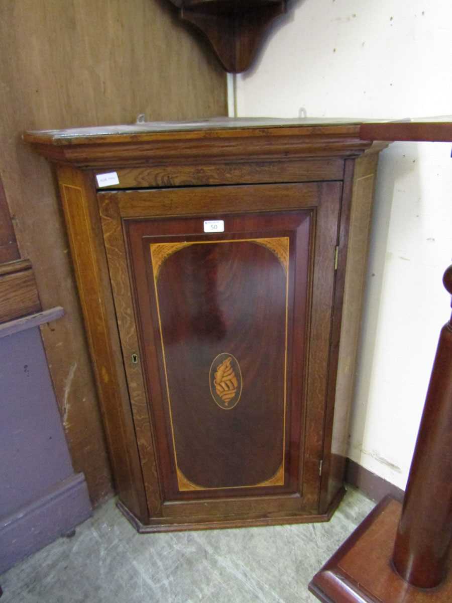 A Georgian inlaid oak wall mounted corner cupboard