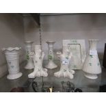 An assortment of seven items of Belleek ceramic ware to include candlesticks, bud vase, easel