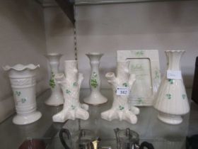 An assortment of seven items of Belleek ceramic ware to include candlesticks, bud vase, easel