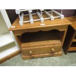 A modern pine bedside cabinet having open storage above single drawer