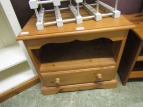 A modern pine bedside cabinet having open storage above single drawer