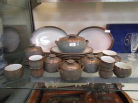 An assortment of Denby 'Greystone' tableware to include meat plates, tureen, cups, saucers, etc